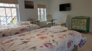 a bedroom with two beds and a dresser at Argyll House Bed and Breakfast in Westleton