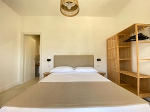 a bedroom with a large bed and a book shelf at Maison Sciscì Rooms in San Felice Circeo
