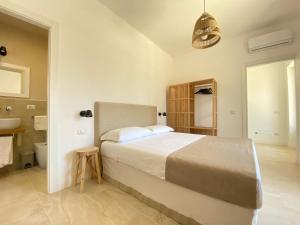 a bedroom with a large bed and a bathroom at Maison Sciscì Rooms in San Felice Circeo
