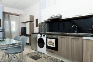 a kitchen with a washing machine and a sink and a table at Luxury Dream House in Limenaria +20 photos