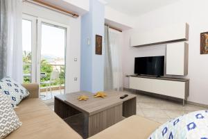 a living room with a couch and a tv at Luxury Dream House in Limenaria