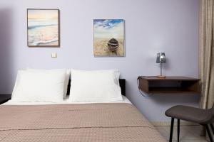 a bedroom with a bed with two pillows and a chair at Luxury Dream House in Limenaria