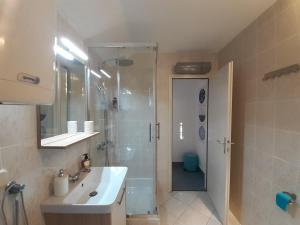 ein Bad mit einer Dusche, einem Waschbecken und einem WC in der Unterkunft Romantic Apartment by the Beach in Malinska