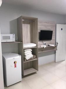 a room with a refrigerator and a desk with a microwave at Apart Hotel CTC - Edifício Araras in Caldas Novas