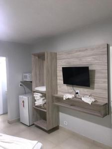 a room with a tv on a wall at Apart Hotel CTC - Edifício Araras in Caldas Novas