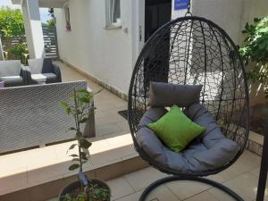 a hanging hammock with a green pillow on a balcony at New Lux Apartman Kala in Poreč