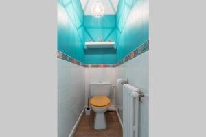 a bathroom with a toilet with a blue ceiling at Logement confort moderne au pied du Front de Mer in Saint-Nazaire +6 photos