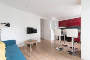 a living room with a blue couch and a table at Logement confort moderne au pied du Front de Mer in Saint-Nazaire
