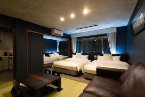 a hotel room with two beds and a couch at Weskii Hotel in Kanazawa