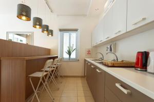 a kitchen with a white counter top and white cabinets at Ta Gianni Guest House in Sliema