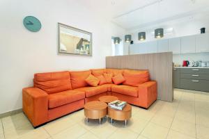 a living room with an orange couch and a table at Ta Gianni Guest House in Sliema