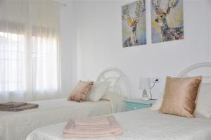 a bedroom with two beds and a painting on the wall at SEVILLA I Y SEVILLA II in La Guardia