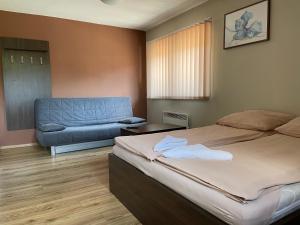 sypialnia z łóżkiem i kanapą w obiekcie Ondraszek-Pokoje Gościnne w Szczyrku