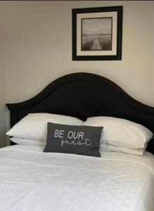 łóżko z czarnym zagłówkiem i białymi poduszkami w obiekcie Rocky Brook Acres w mieście Cormack