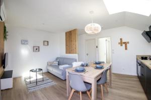 ein Wohnzimmer mit einem Tisch und einem Sofa in der Unterkunft LOUE ET PASSION - DOMAINE LOUE PAISIBLE - Calme - Terrasse - Parking in Chouzelot