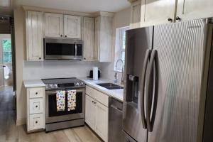 a kitchen with stainless steel appliances and white cabinets at Farm House stay with soaking tub and hot tub barn in Hammond