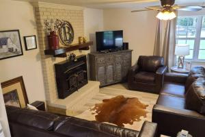 a living room with a couch and a fireplace at Farm House stay with soaking tub and hot tub barn in Hammond