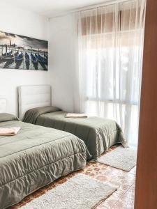 una camera con due letti e una finestra di Venezia Appartamenti a Quarto dʼAltino