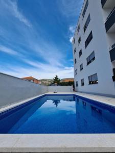 a swimming pool in front of a building at Apartments Angelus in Trogir