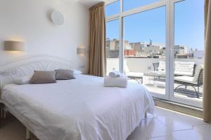 a hotel room with a bed and a television at Ta Gianni Guest House in Sliema