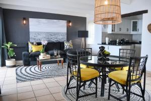 a kitchen and living room with a table and chairs at Palm Cove - 10 Thira, Santorini, best view over Thompsons Beach in Ballito +26 photos
