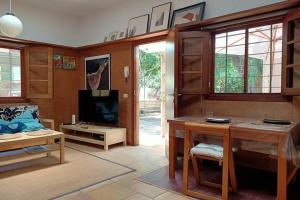 sala de estar con mesa y TV en Apartamento-Bungalow con jardín y garaje, en Santa Cruz de Tenerife
