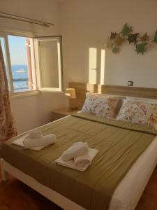 a bedroom with a large bed with towels on it at Katerina Apartments & Studios in Naousa