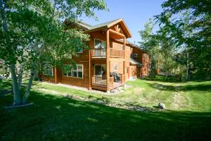 a log cabin with a yard in front of it at Bear Creek Lodge Townhome in Steamboat Springs