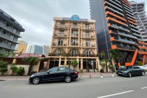 two cars parked in front of a building at Hotel Eurasia in Batumi