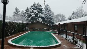 a swimming pool covered in snow in front of a house at Mont Blanc in Villa General Belgrano