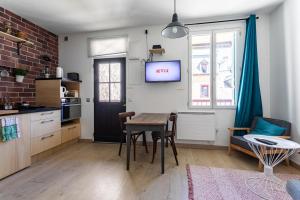 uma cozinha e sala de jantar com uma mesa e uma televisão em LE JACOBIN 2 em Rennes