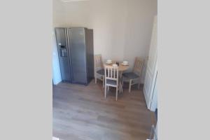 uma cozinha com uma mesa e um frigorífico em Supeluse 6/2 külaliskorter em Pärnu