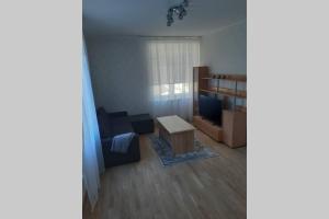 uma sala de estar com um sofá e uma mesa em Supeluse 6/2 külaliskorter em Pärnu