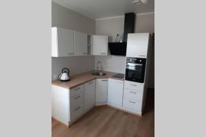 a kitchen with white cabinets and a refrigerator at Supeluse 6/2 külaliskorter in Pärnu