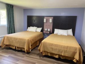 two beds in a hotel room with two at Scottish Inn - North Tonawanda in Tonawanda