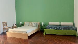 ナポリにあるCasa del Plebiscitoの緑の壁とウッドフロアの客室で、ベッド2台が備わります。