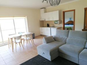 uma sala de estar com um sof e uma mesa e uma cozinha em Casas d'Almofala em Vila de Rei