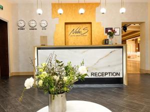un grande schermo televisivo con un vaso di fiori in un negozio di NeboS Hotel & Restaurant a Ivano-Frankivsʼk