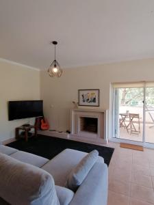uma sala de estar com um sof e uma lareira em Casas d'Almofala em Vila de Rei