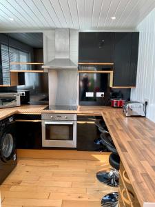 a kitchen with black cabinets and a wooden counter top at No 10 The Cottage in Inverness