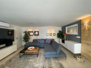 a living room with a blue couch and a table at VILLA OD MOORE STARIGRAD in Starigrad-Paklenica