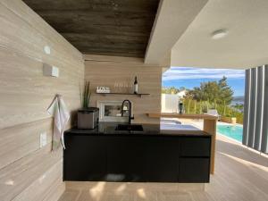 a kitchen with a black counter top and a large window at VILLA OD MOORE STARIGRAD in Starigrad-Paklenica