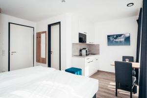 1 dormitorio con cama, escritorio y cocina en SmartLiving Apartments München, en Múnich