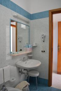 bagno con lavandino e specchio di Hotel Maronti a Ischia