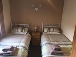 two beds sitting next to each other in a bedroom at Riverbank Cottage in Fort William