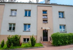 un edificio de apartamentos con una puerta principal y arbustos en Apartament u Janka, en Wieliczka