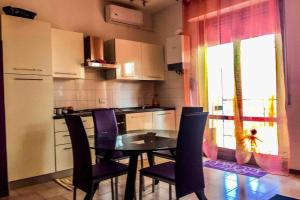 eine Küche mit einem Tisch und Stühlen sowie einem Fenster in der Unterkunft Appartamento in Residence Santa Monica in Campomarino