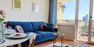 a living room with a blue couch and a table at Sea View Mieszknie na Wynajem Gdynia z Widokiem na Morze Dworzec Centrum in Gdynia
