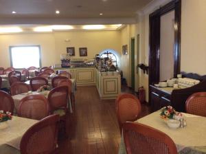 a restaurant with tables and chairs in a room at Cavalieri Hotel in Corfu Town
