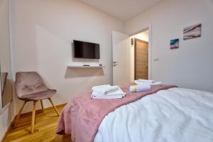 1 dormitorio con 1 cama, 1 silla y TV en Apartman BB Zlatibor en Zlatibor